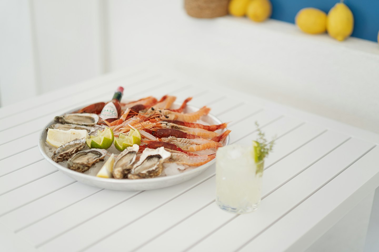A seafood platter with oysters and shrimp rests on ice.