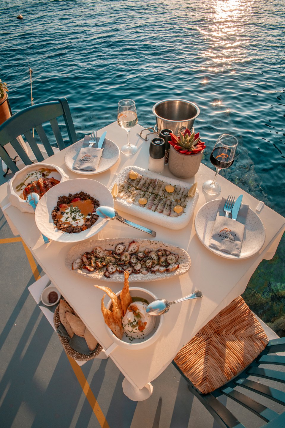 Gourmet seafood and wine served on a table by the sea.