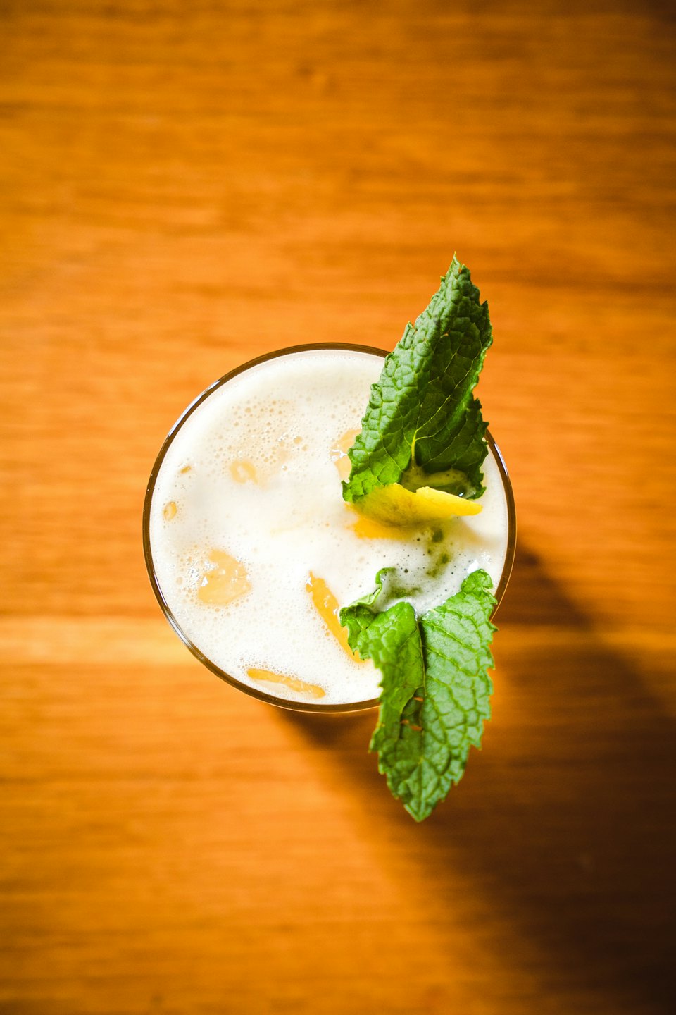 A refreshing cocktail with mint and citrus on a wooden table.